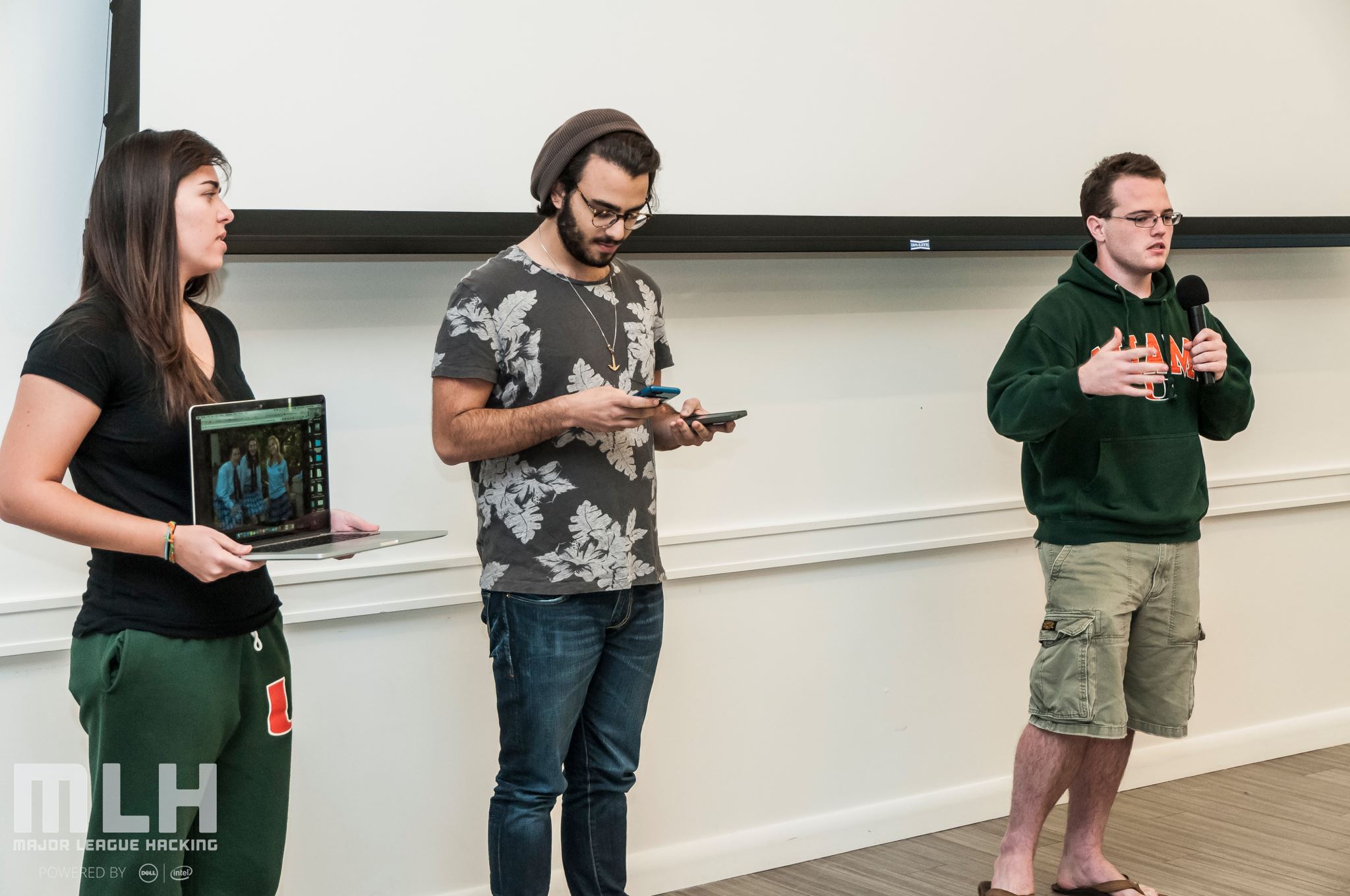 three college students standing and presenting a project